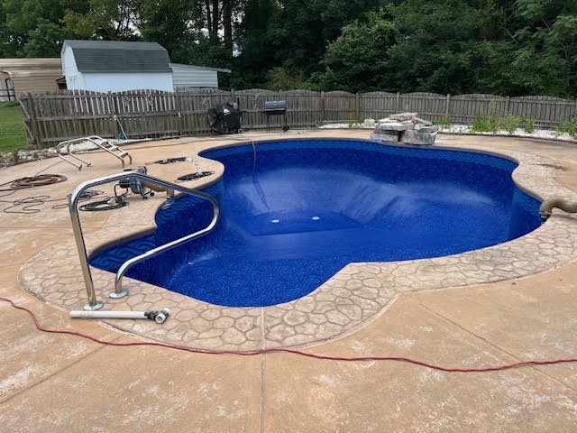 After: Freeform pool with stamped concrete deck &mdash; new vinyl liner